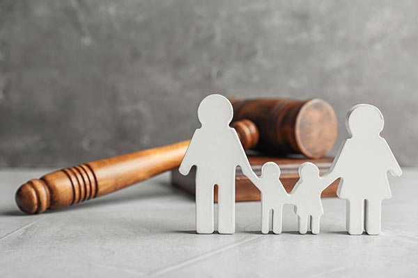 Une famille en jouet avec un martau de juge en arrière plan