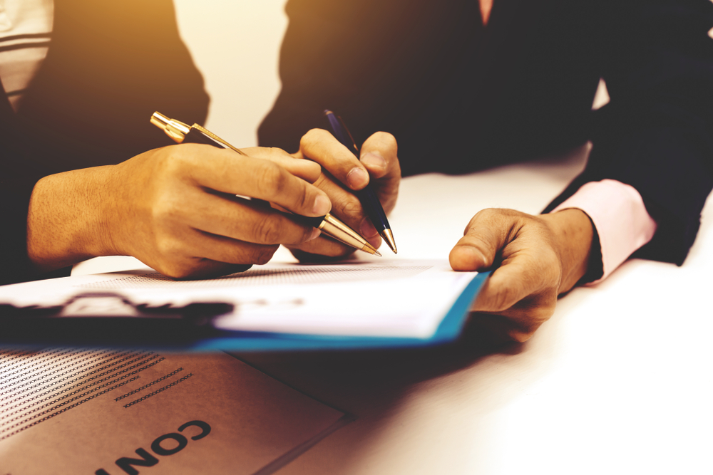 Deux personnes en train de signer un contrat