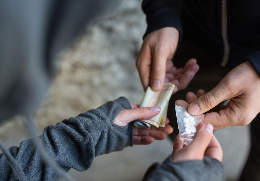 Deux personnes en train de s'échanger de l'argent contre des produits stupéfiants